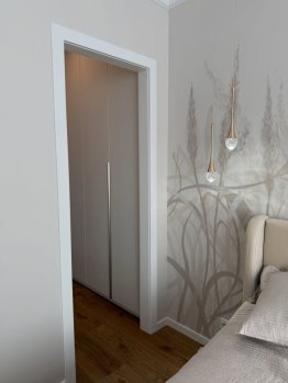  Průchozí obložka, která elegantně rámuje vstup do šatny a zachovává vzdušnost interiéru.