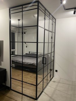Skleněné dveře a příčky s černým kovovým rámem 